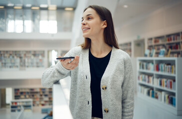 Phone, library and university woman in a education and learning building with a mobile talking....