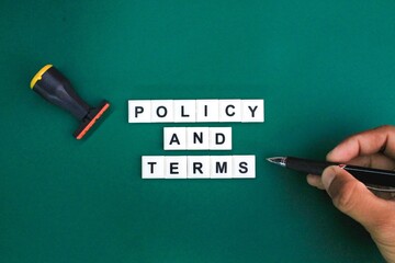 stamp and a hand holding a pen with the word policy and terms. the concept of terms and conditions