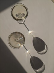 Two glasses of white wine on the white table in natural sunlight