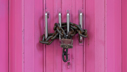 Pink gate locked with a chain and padlock