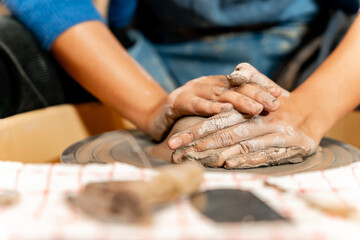 Obraz premium earthenware The art of sculpting clay with ceramics being molded by hand on a spinning machine. with the right posture to create a plate or vase professionally