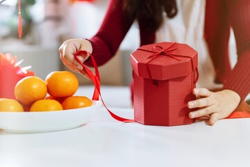 Asian Woman holding red gift box thankful present Lunar New Year. Chinese traditional holiday....