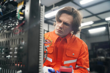 Electrical engineers test electrical installations and wiring on protective relays, measuring them with a multimeter.