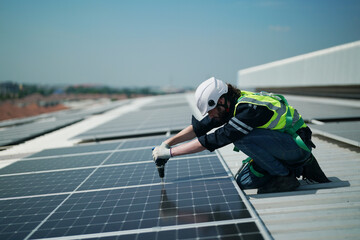 A worker is fixing solar panels on the roof. Engineer and technician using laptop checking and operating solar panels system on rooftop of solar cell farm power plant, Renewable energy source.