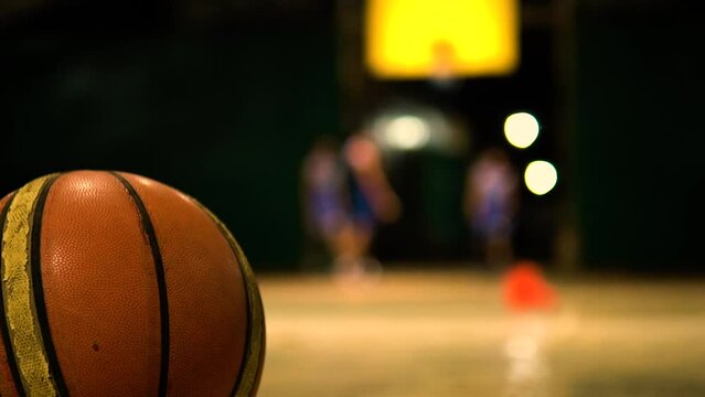 basket ball on the ground while players are on the background