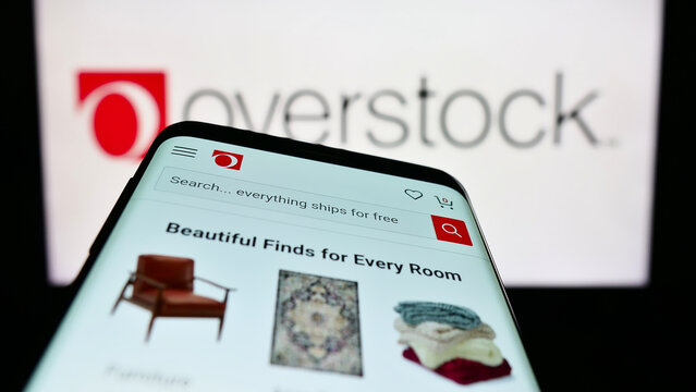 Stuttgart, Germany - 01-14-2023: Mobile phone with webpage of US e-commerce company Overstock.com Inc. on screen in front of business logo. Focus on top-left of phone display.