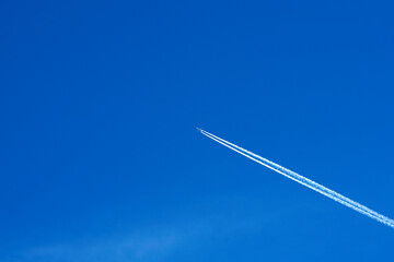 Passenger jet leaving a condensation trail in a blue sky