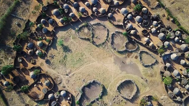 Aerial drone zoom out view from the center of a village in the Karamoja region, also called Manyatta or Ere, in Uganda, during a sunny day.