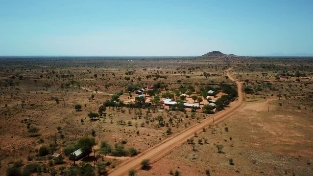 Panoramic drone shot approaching an African village in Karamoja, also called Manyattas in Uganda on a sunny day. High quality 4k footage.