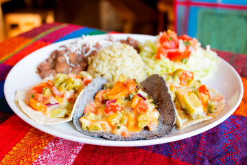 Vegetarian tacos. A taco is a traditional Mexican food consisting of a small hand-sized corn tortilla