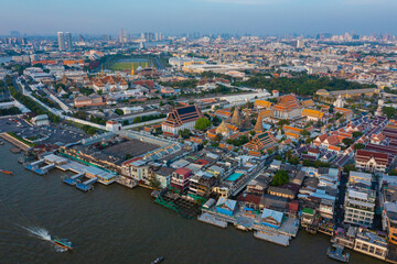 Fototapeta na wymiar Aerial view Day to Night of Chao Phraya River with Royal Grand Palace and Emerald Buddha Temple Landmark of Bangkok, Thailand. Amazing Drone Footage over the City skyline in twilight.