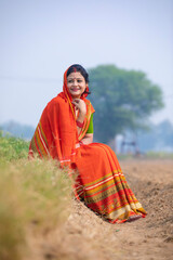Indian rural woman in traditional saree at agriculture field.