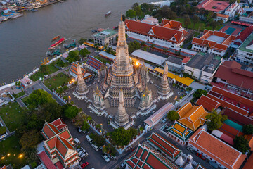 Fototapeta premium Aerial view Day to Night of Chao Phraya River with Royal Grand Palace and Emerald Buddha Temple Landmark of Bangkok, Thailand. Amazing Drone Footage over the City skyline in twilight.