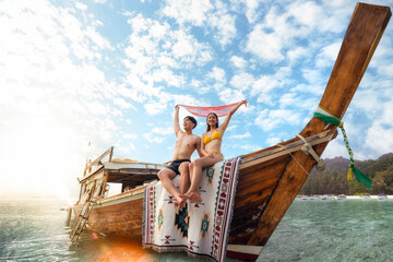 Asian couple lover travel and relax in they honeymoon trip on the wooded boat - obrazy, fototapety, plakaty