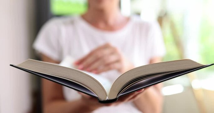 Woman reading book and flipping through pages closeup 4k movie slow motion 