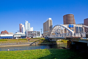Obraz premium Mount Iwate scene with buildings and promenade at Katakami river in Morioka city, Iwate prefecture, Tohoku, Japan.