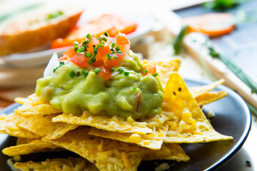Nachos with guacamole. Nachos are a dish of Mexican origin, which consists of frying pieces of corn tortilla covered with a special cheese.
