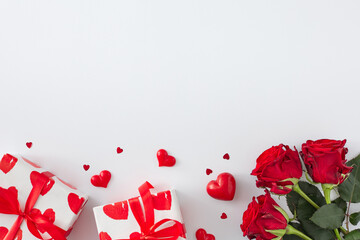 Women day presents concept. Top view photo of red flowers, gift boxes and hearts on white background with copy space. 8-march holiday card idea.