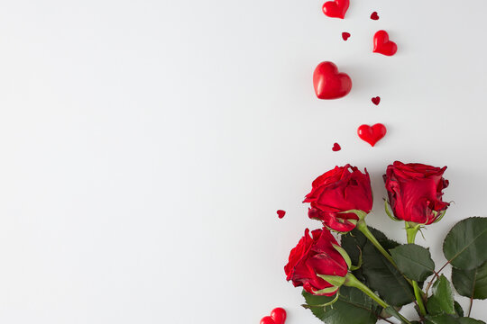 Mother day concept. Flat lay photo of roses and red hearts on white background with copy space. 8-march holiday card idea.