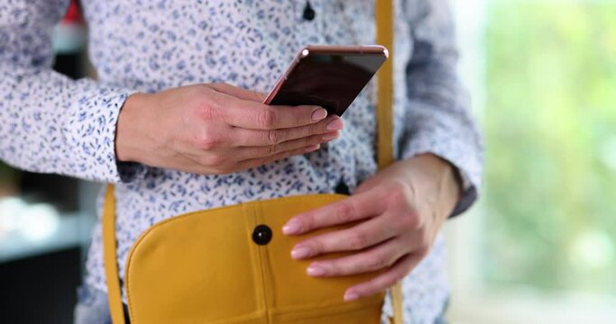 Woman taking mobile phone out of her leather purse closeup 4k movie slow motion 