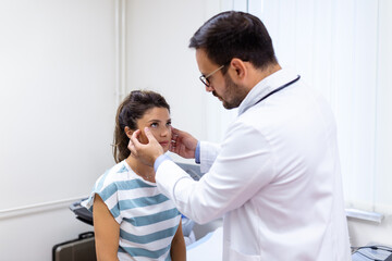 Adult woman having a visit at oculist's office. Doctor examining eyes of young woman in clinic.