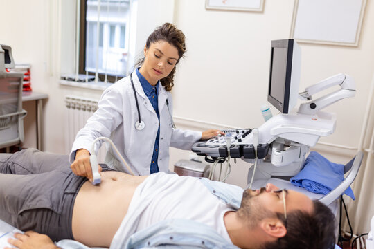 Ultrasound Diagnosis Of The Stomach On The Abdominal Cavity Of A Man In The Clinic, Close-up View. The Doctor Runs An Ultrasound Sensor Over The Patient's Male Abdomen. Diagnostics Of Internal Organs.