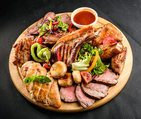 grilled potatoes and meat with various sauces and greens