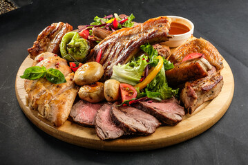 grilled potatoes and meat with various sauces and greens
