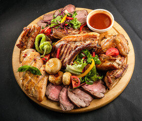 grilled potatoes and meat with various sauces and greens