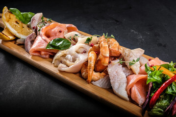 assorted fish and seafood on a wooden tray