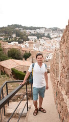 A tourist climbs up to the observation deck. against the backdrop of an old town