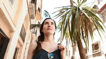 A young girl is traveling in Spain. Against the background of the flag