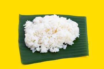 Sticky rice on banana leaf on yellow background.