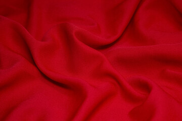 Red fabric background. Red cloth waves background texture. Red fabric cloth textile material.