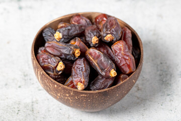 Date fruit on stone background. Organic Medjoul dates in a glass bowl. Ramadan food. close up