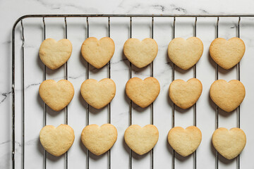 Freshly baked heart shaped shortbread cookies on a cooling rack