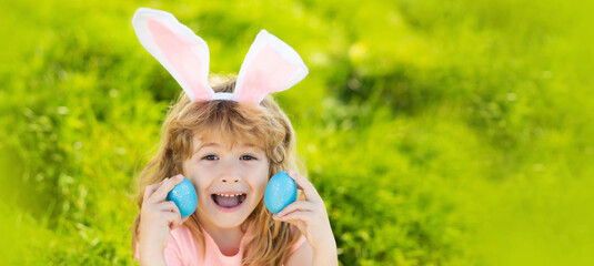 Bunny easter child. Kids hunting easter eggs. Boy with easter eggs and bunny ears in backyard. Horizontal photo banner for website header design with copy space for text.