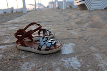 Sandals on a white wooden track covered with sand. Beach