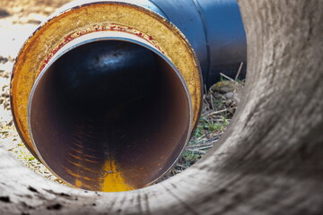 Insulated pipe. Large metal pipes with a plastic sheath at a construction site. Modern pipeline for supplying hot water and heating to a residential area. Close-up.