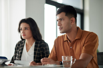 Serious young couple meeting with insurance agent in office