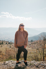 Naklejka premium Woman on the rocks at sunny day. Woman having trekking in the mountains in Turkey. Trekking concept. 