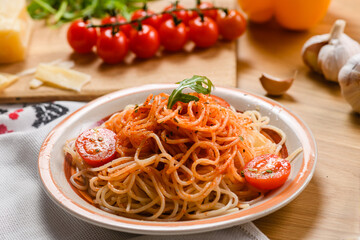 Pasta with tomatoes on the background of parmesan cheese, garlic, herbs and cherry tomatoes.