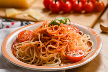 Pasta with tomatoes on the background of parmesan cheese, garlic, herbs and cherry tomatoes.