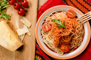 Whole grain spaghetti pasta with cherry tomato in a bowl.