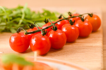Sprig of cherry tomatoes on the table, close-up.