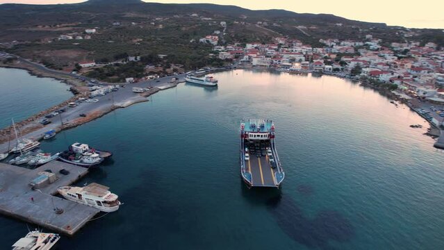 Aerial video of  Elafonisos main village with a fery leaiving the port  during sunset