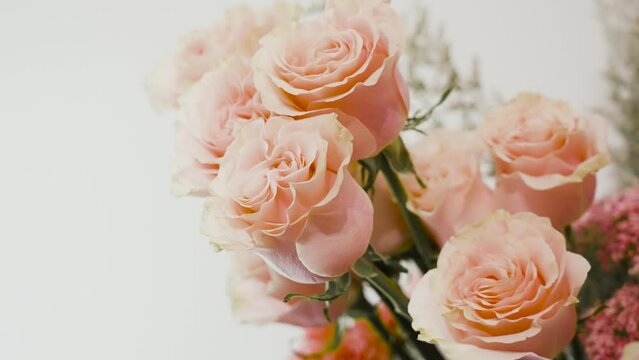 A Florist adjusting pink roses for a bouquet.