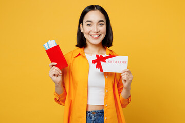 Young woman in summer casual clothes hold passport ticket gift voucher card isolated on plain...