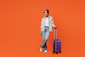 Full body traveler woman of African American ethnicity wear casual clothes hold bag isolated on plain background studio. Tourist travel abroad in free spare time rest getaway. Air flight trip concept.