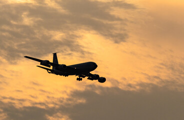 Fototapeta na wymiar Airplane flying in the sunset sky